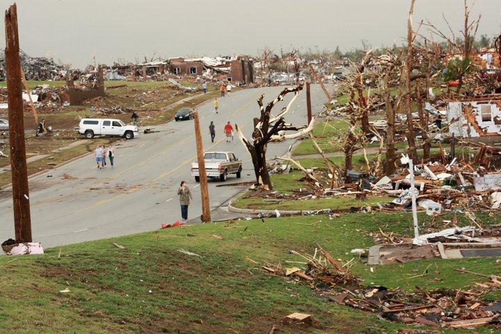 Entire city block bulldozed by the tornado, trees left splintered.
